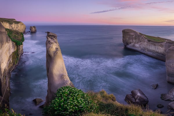 A coastal landscape with a prominent rock formation and cliffs.