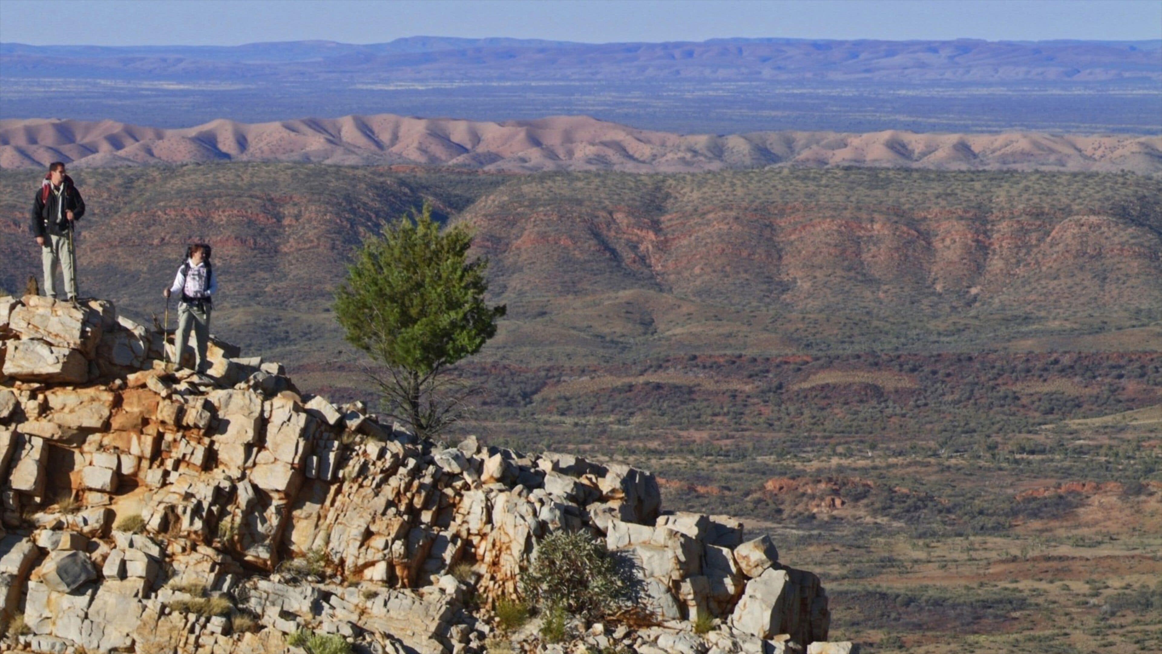 Larapinta Trail Trailhead which includes hiking or walking and tranquil scenes as well as a small group of people
