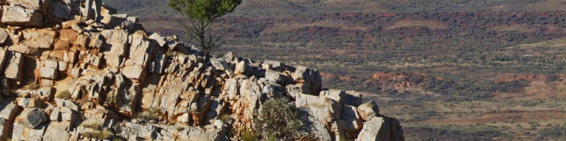 Larapinta Trail Trailhead which includes hiking or walking and tranquil scenes as well as a small group of people