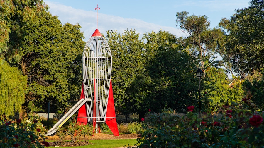 A red and white tower-like structure with a slide in a park.