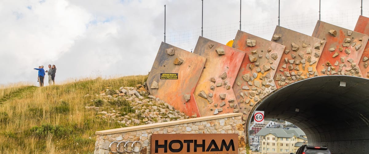 Mount Hotham Alpine Resort which includes a bridge and signage as well as a small group of people