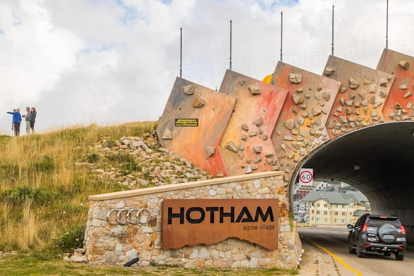 Mount Hotham Alpine Resort which includes a bridge and signage as well as a small group of people