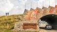 Mount Hotham Alpine Resort which includes a bridge and signage as well as a small group of people