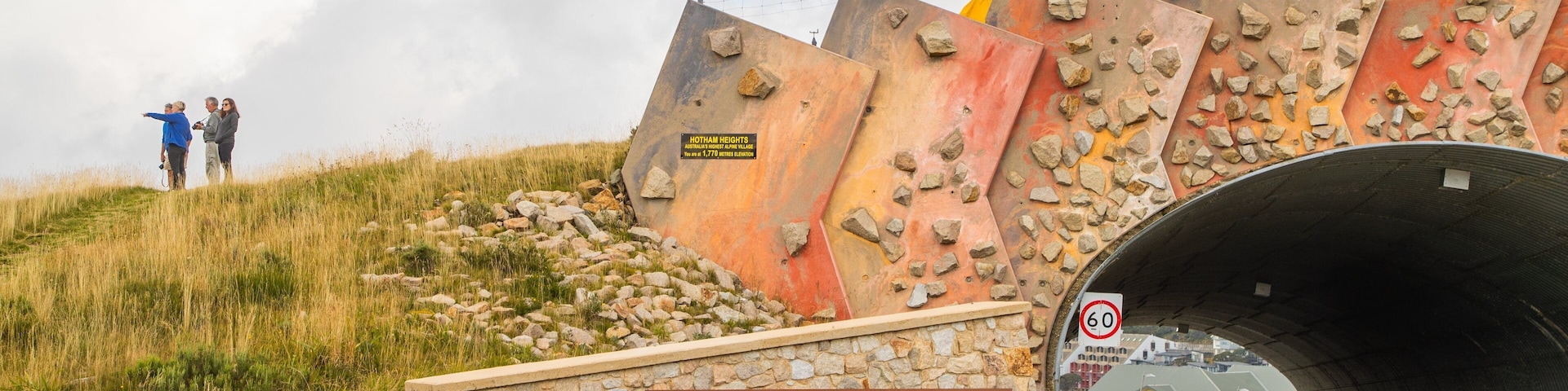 Mount Hotham Alpine Resort which includes a bridge and signage as well as a small group of people