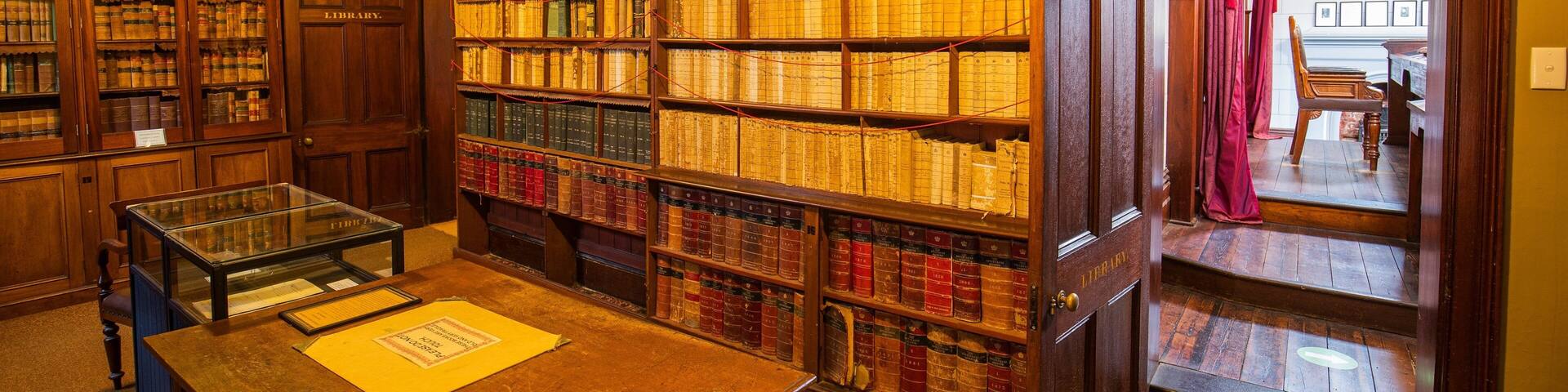 A library with wooden bookshelves filled with books.