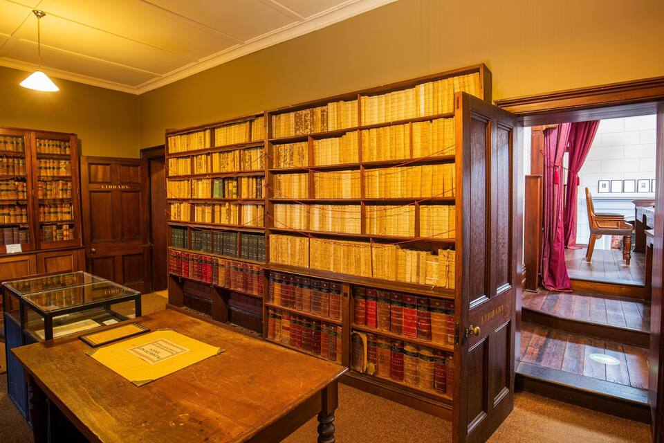 Eine Bibliothek mit hölzernen Bücherregalen voller Bücher.