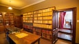 A library with wooden bookshelves filled with books.