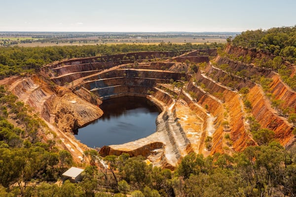A large open-pit mine with terraced walls and a central water body.