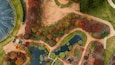 An aerial view of a park with winding paths, ponds, and a variety of trees in autumn colors.