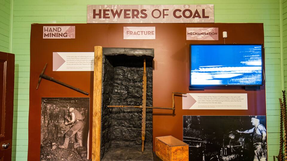 A display titled 'HEWERS OF COAL' with signs about hand mining, fracture, and mechanisation.