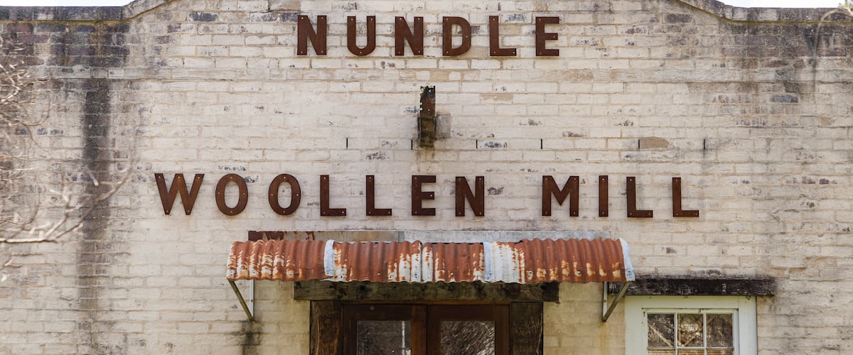 A weathered building with the sign "NUNBLE WOOLLEN MILL".