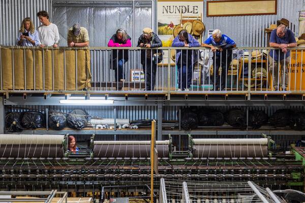 A textile factory with machinery and workers on the upper level.