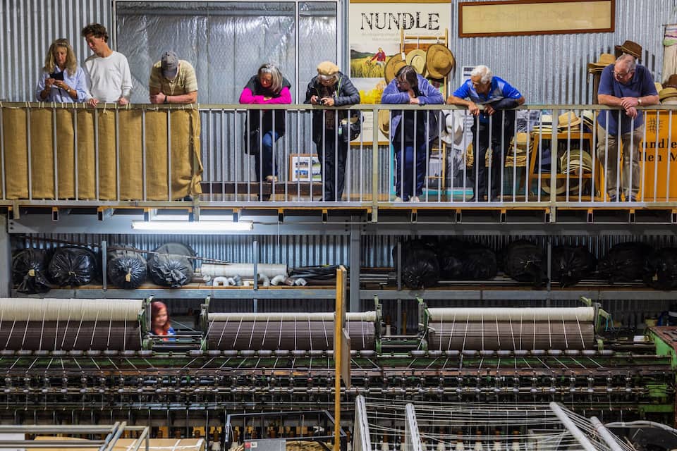 A textile factory with machinery and workers on the upper level.