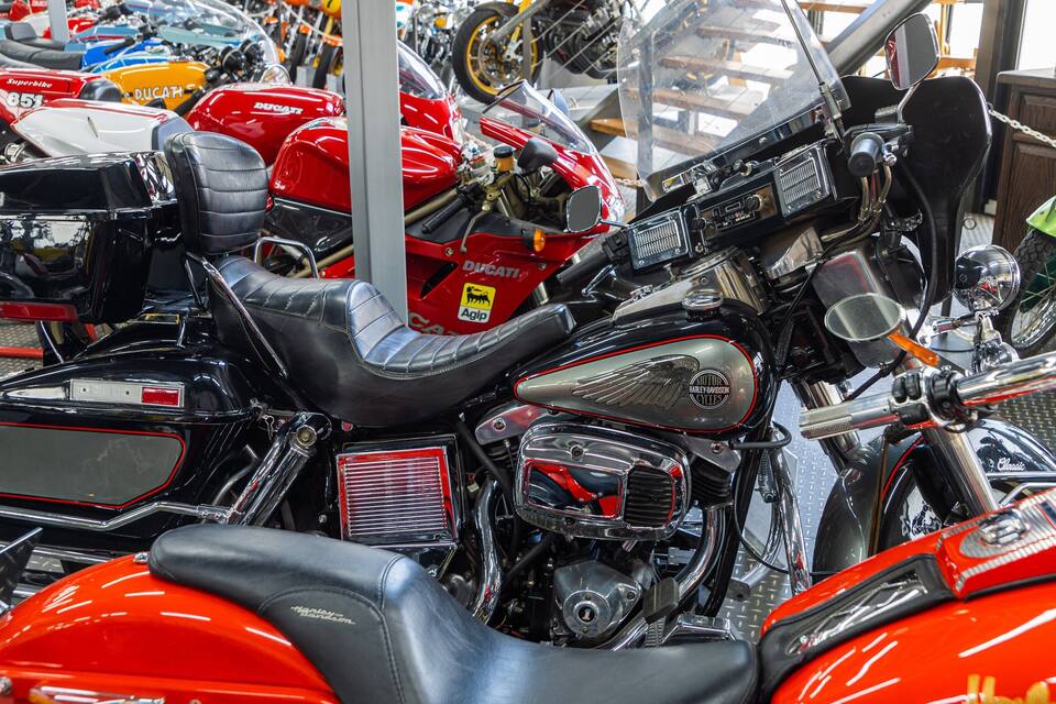 A collection of motorcycles, including a Harley-Davidson and a Ducati, parked closely together.