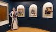 Een museumexpositie met ingelijste foto's en een groot poster.