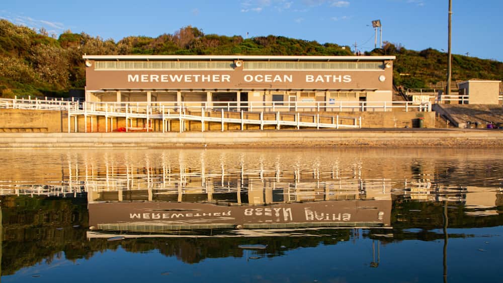 A building labeled "Merewether Ocean Baths" with a reflection in the water.
