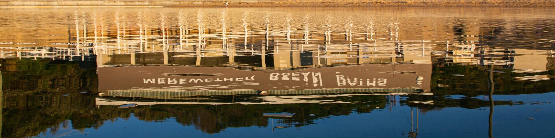 A building labeled "Merewether Ocean Baths" with a reflection in the water.