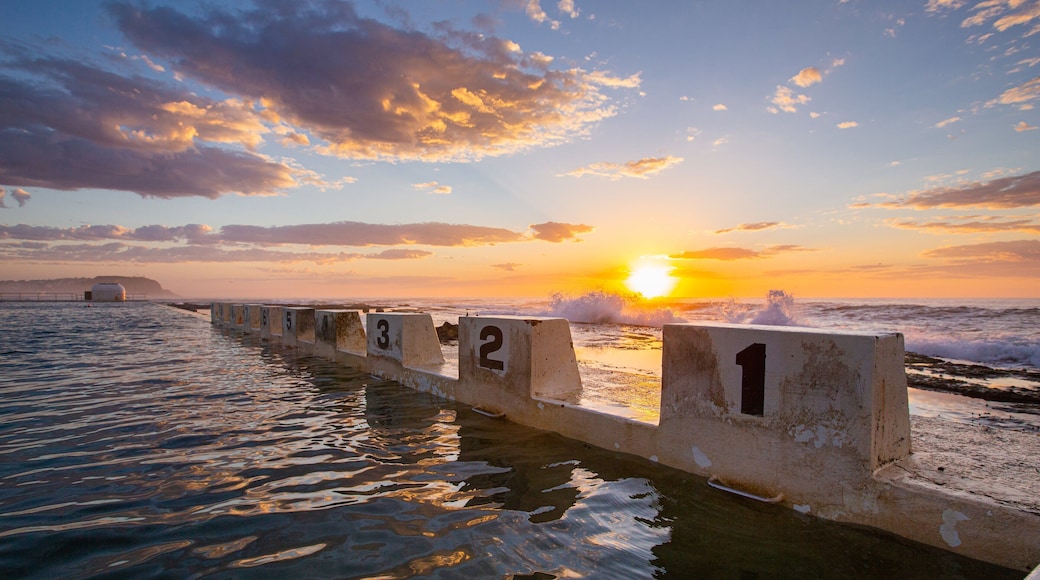 Merewether Ocean Baths which includes general coastal views, signage and a sunset