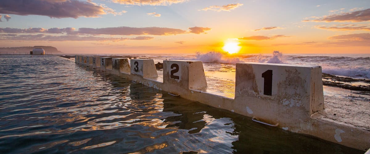 Merewether Ocean Baths which includes general coastal views, signage and a sunset