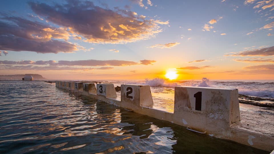 Merewether Ocean Baths which includes general coastal views, signage and a sunset
