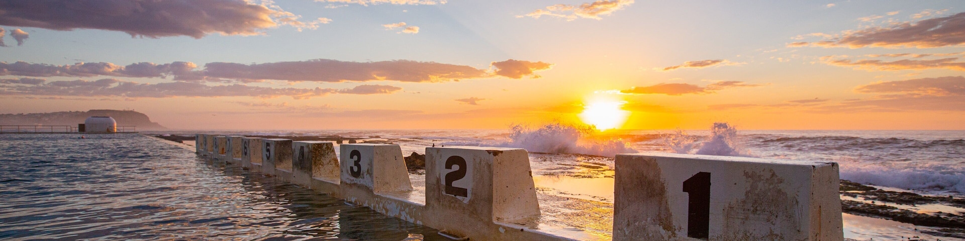 Merewether Ocean Baths which includes general coastal views, signage and a sunset