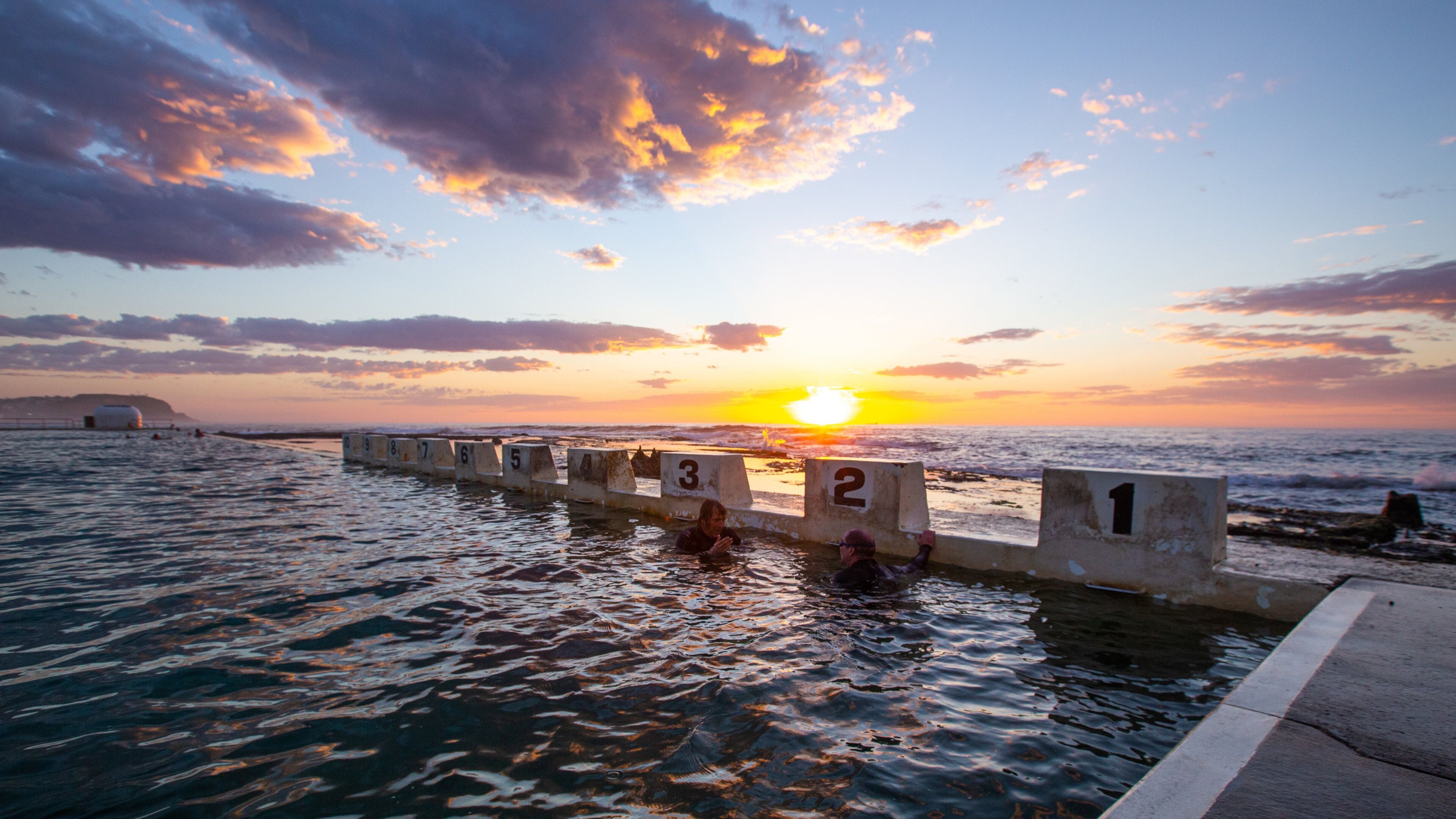 Merewether Ocean Baths featuring a sunset, general coastal views and a pool