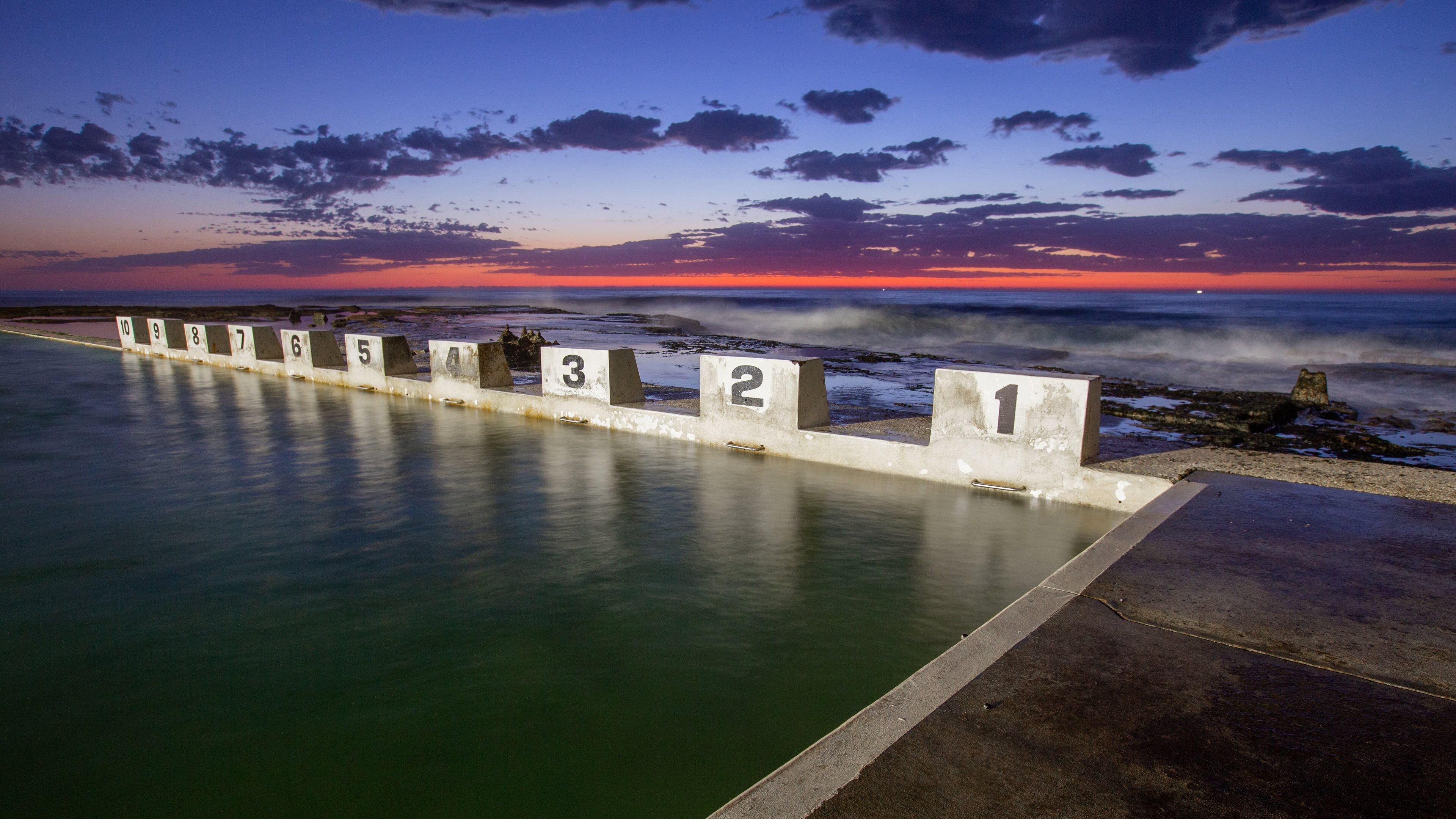 Merewether Ocean Baths which includes general coastal views, signage and a sunset