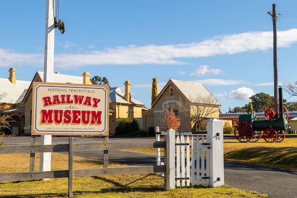 A historic railway museum sign, a vintage train, and traditional buildings.