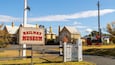 A historic railway museum sign, a vintage train, and traditional buildings.