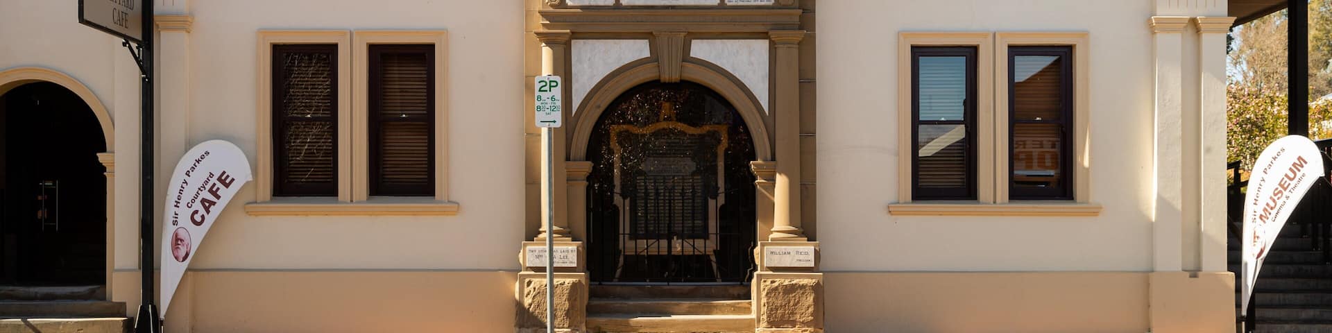 Un edificio con un cartel que dice "Escuela de Artes" y "Café del Patio".