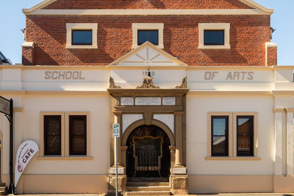 A building with a sign reading "School of Arts" and "Courtyard Cafe".