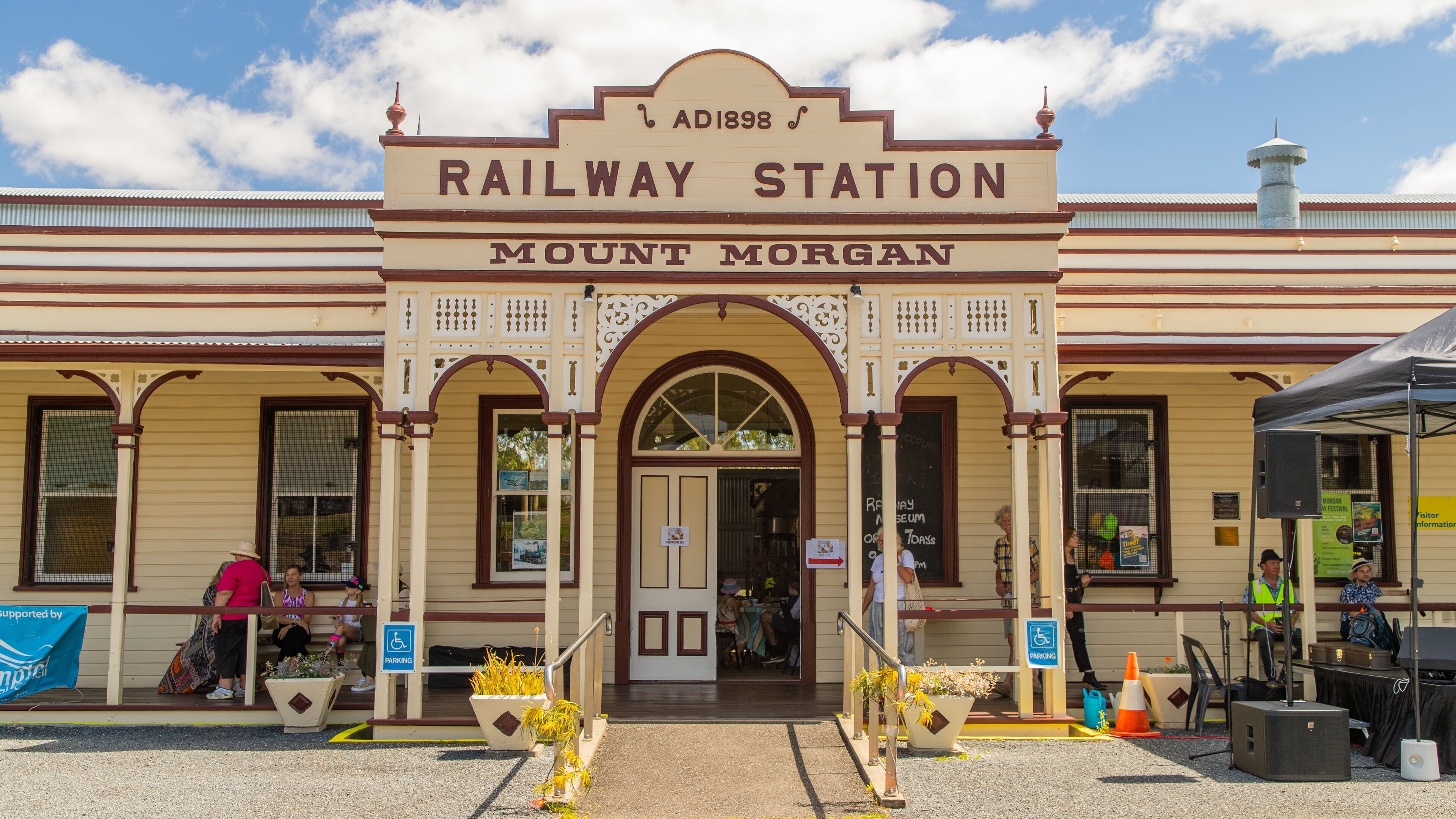 A historic railway station with a sign reading "Railway Station Mount Morgan."