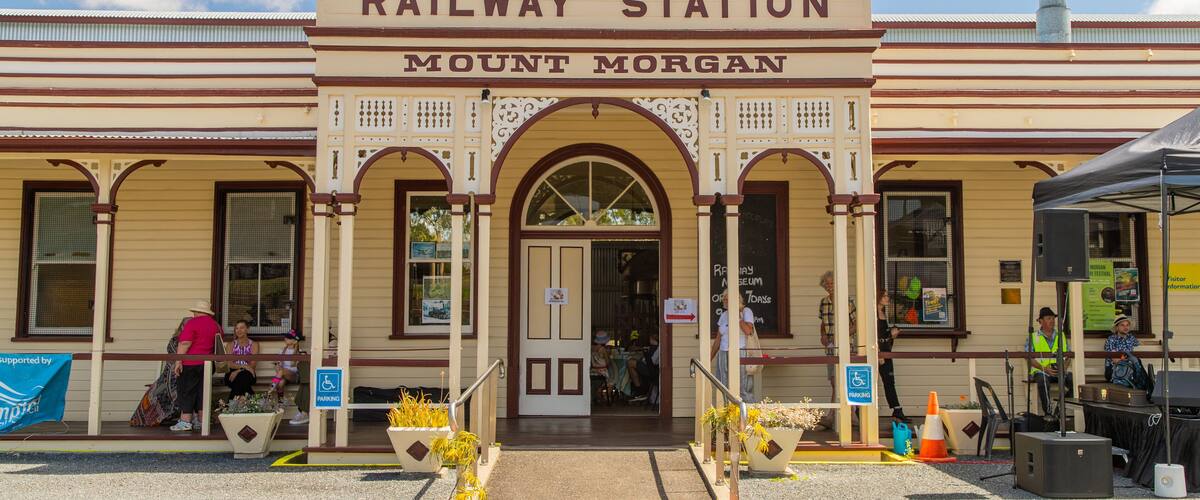 A historic railway station with a sign reading "Railway Station Mount Morgan."
