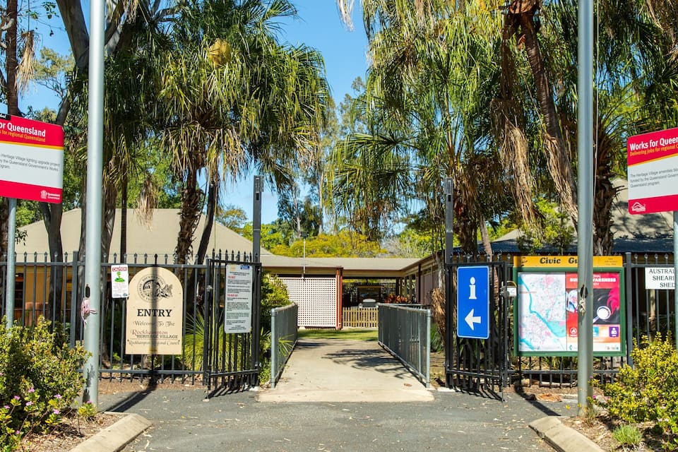 A gate entrance to Rockhampton Heritage Village with informational signs and a map display.