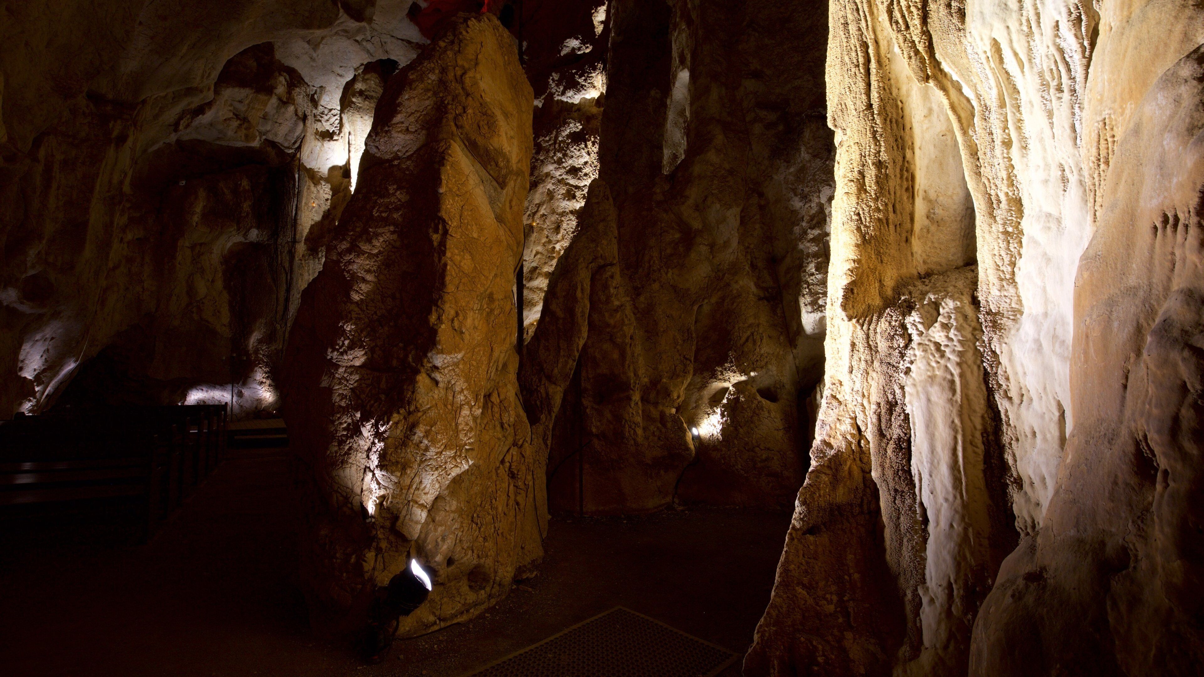 A cave with large rock formations and a wooden chair.
