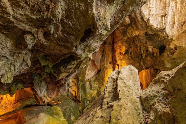 Une grotte ornée de stalactites et de stalagmites, éclairée par un système d’éclairage artificiel.