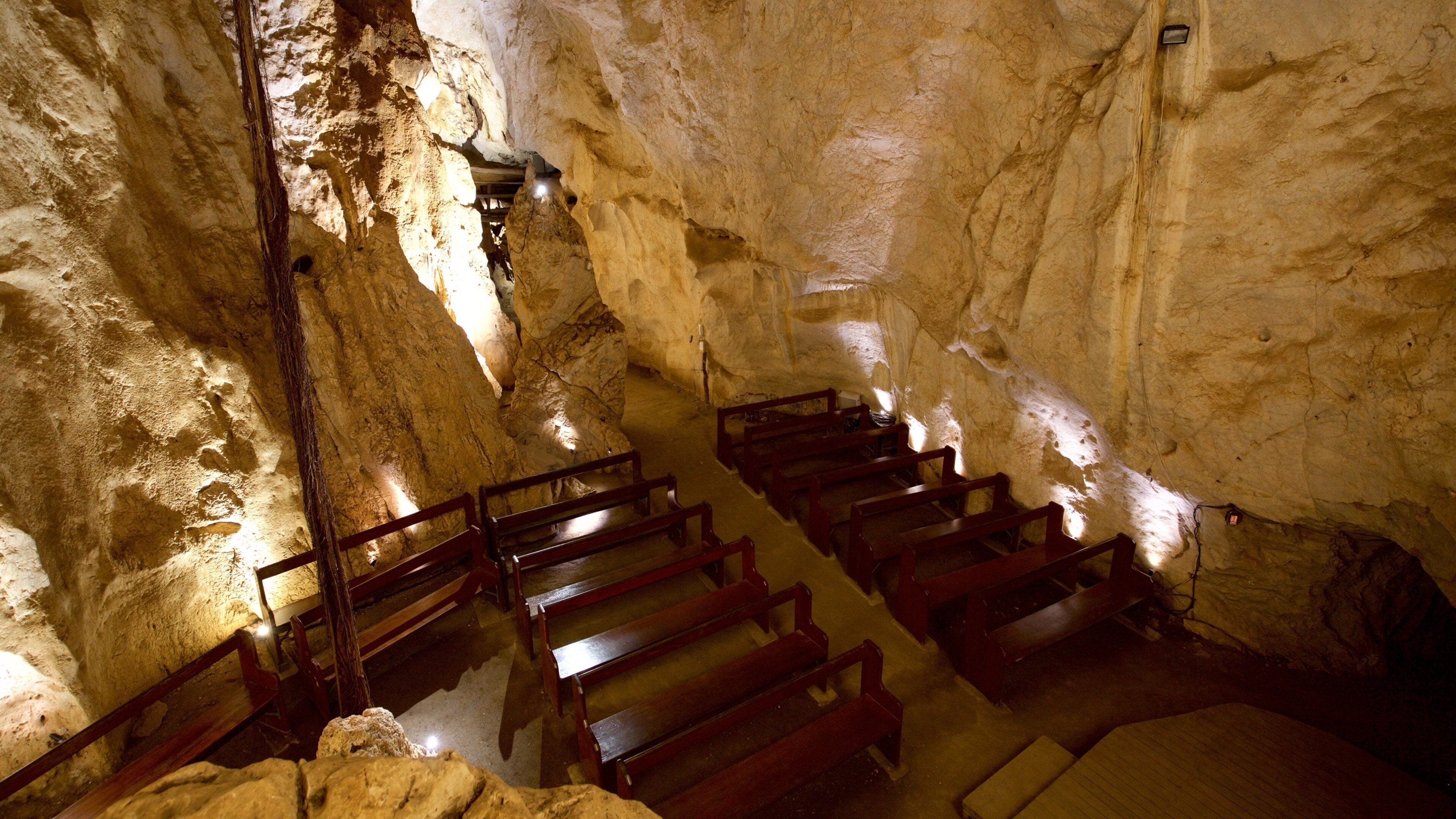 A cave with wooden benches and a staircase.
