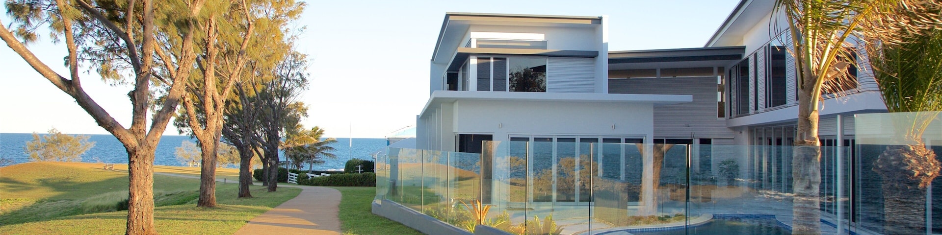 Bargara que incluye una casa, vista general a la costa y un atardecer