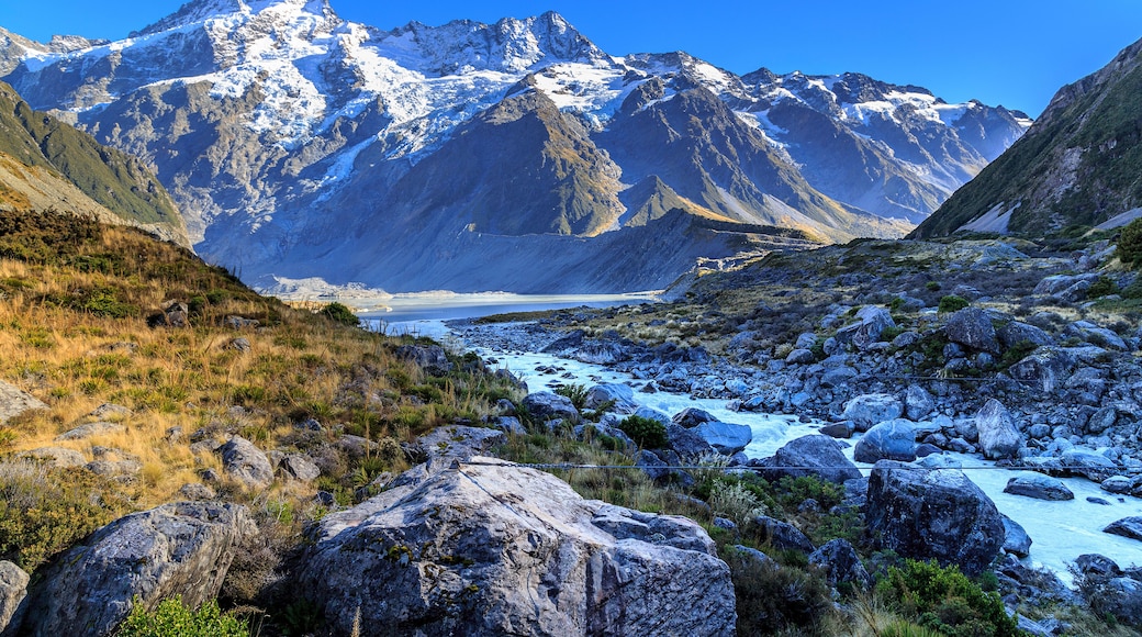 Aoraki/Mount Cook, Hooker Valley track with snowy mountain of Sefton mont, Mueller lake and river against blue sky, a must Hiking Trail destination in Queenstown, New Zealand