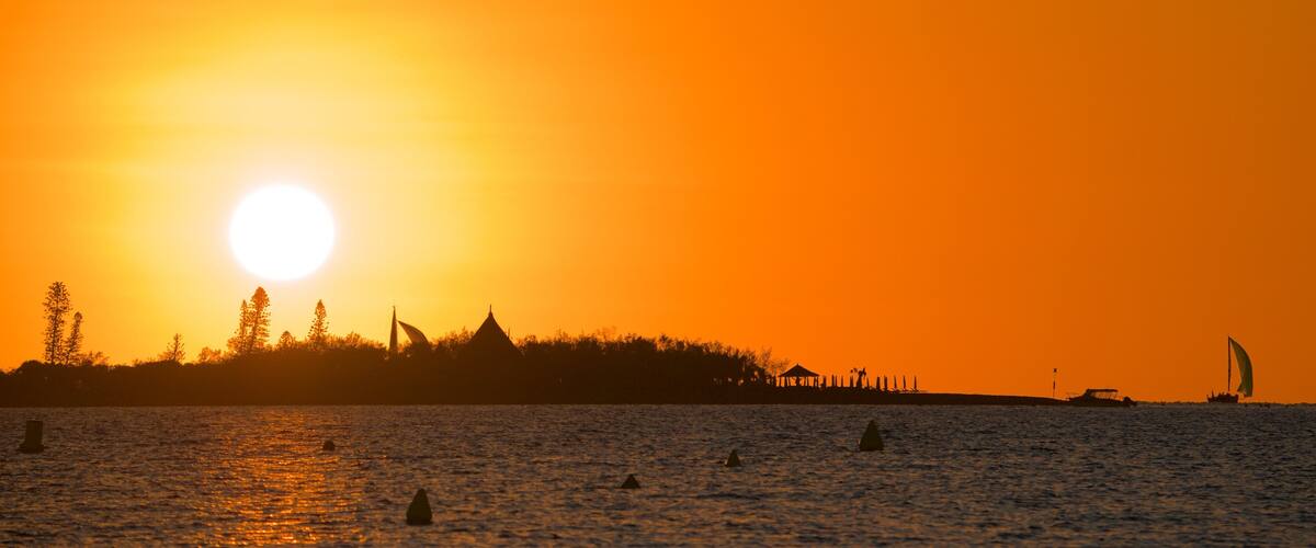 Noumea som inkluderer solnedgang og kyst