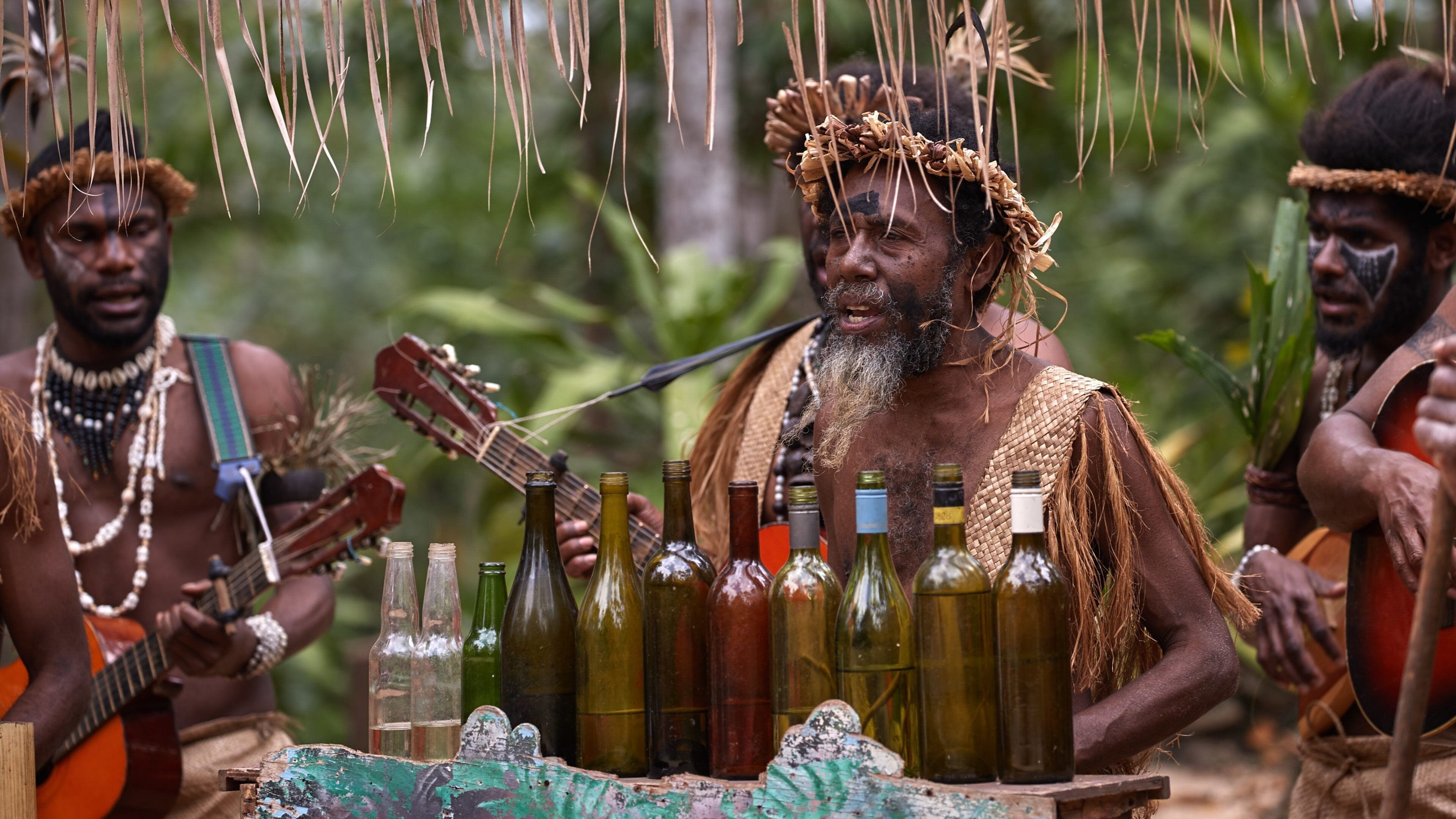 A group of people in traditional attire with musical instruments and bottles of wine.