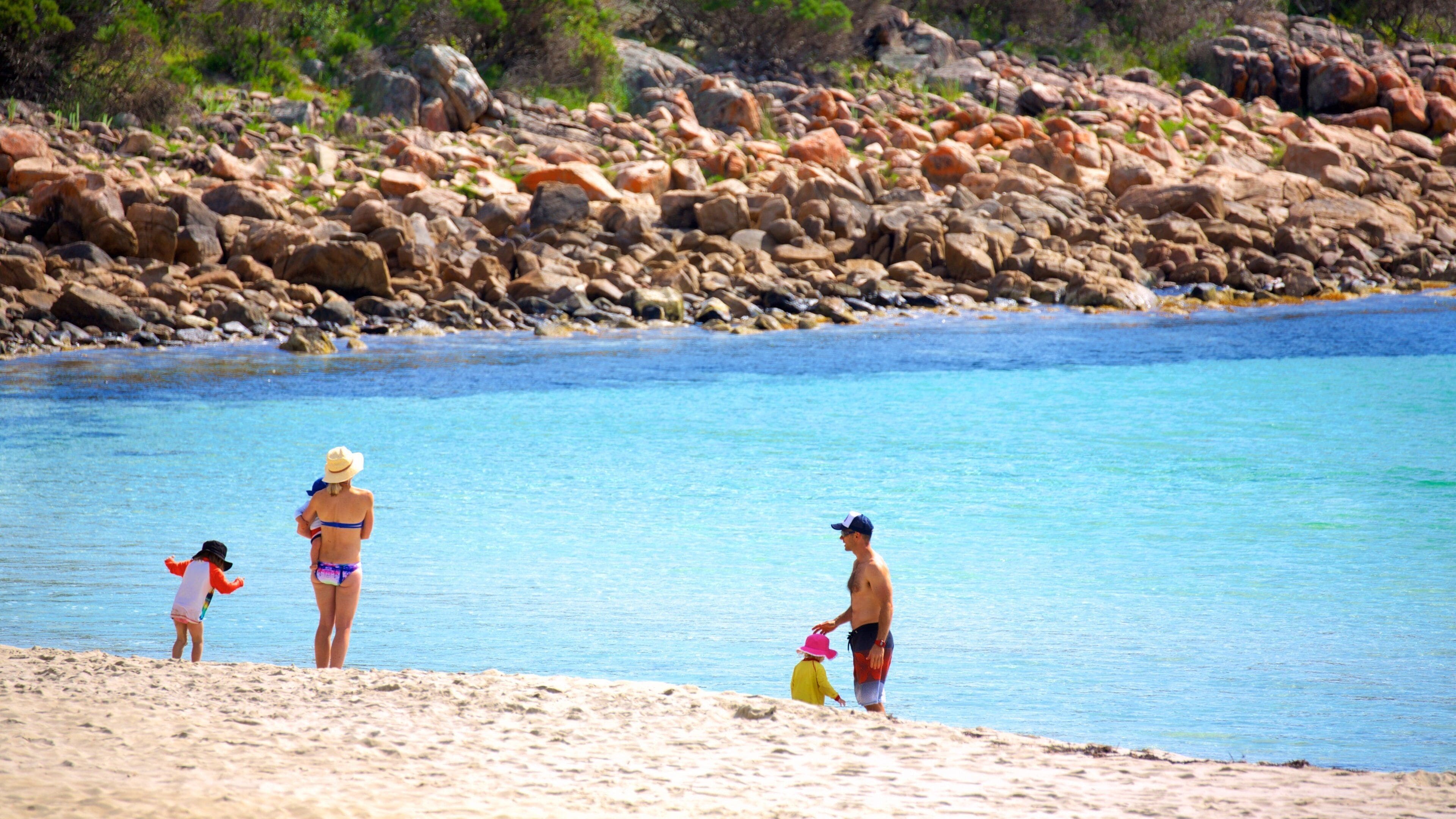 Naturaliste mostrando costa rocciosa e spiaggia sabbiosa cosi come un piccolo gruppo di persone