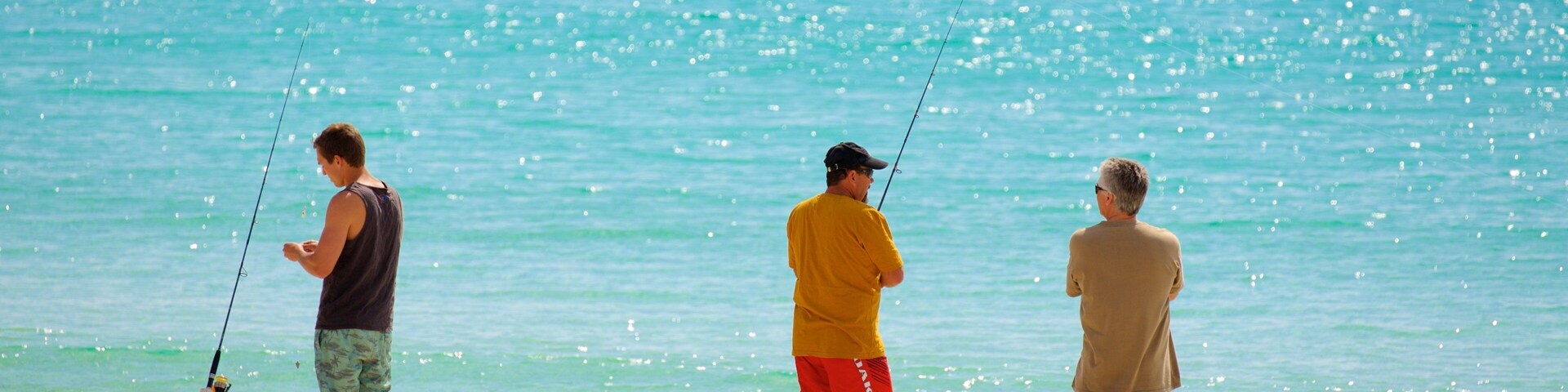 Naturaliste das einen Sandstrand und Angeln sowie kleine Menschengruppe