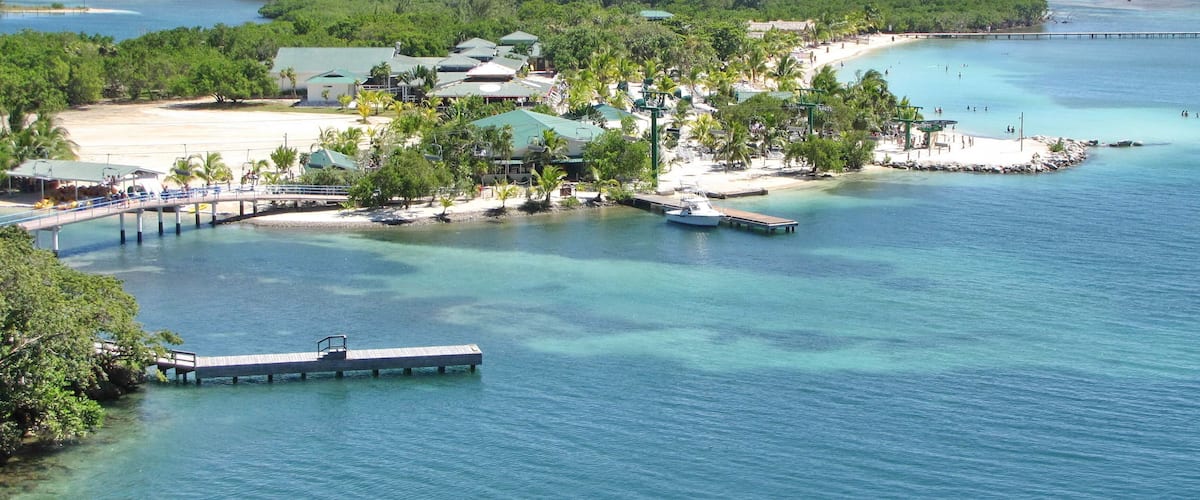 A coastal resort with a pier, beach, and clear turquoise waters.