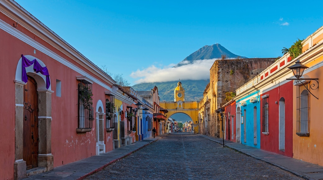 Cityscape of Antigua city at sunrise with Santa Catalina arch and Agua volcano, Guatemala.