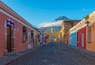 Cityscape of Antigua city at sunrise with Santa Catalina arch and Agua volcano, Guatemala.