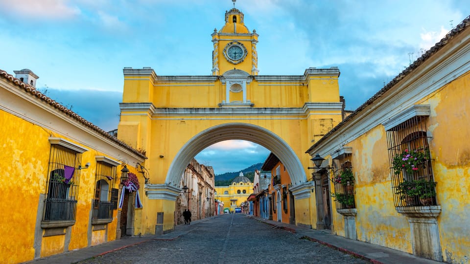 The Santa Catalina arch and the main street of Antigua city at sunrise, Guatemala.