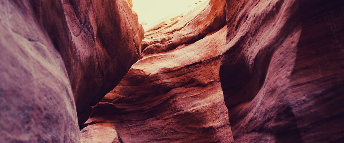 A narrow canyon with layered rock formations.