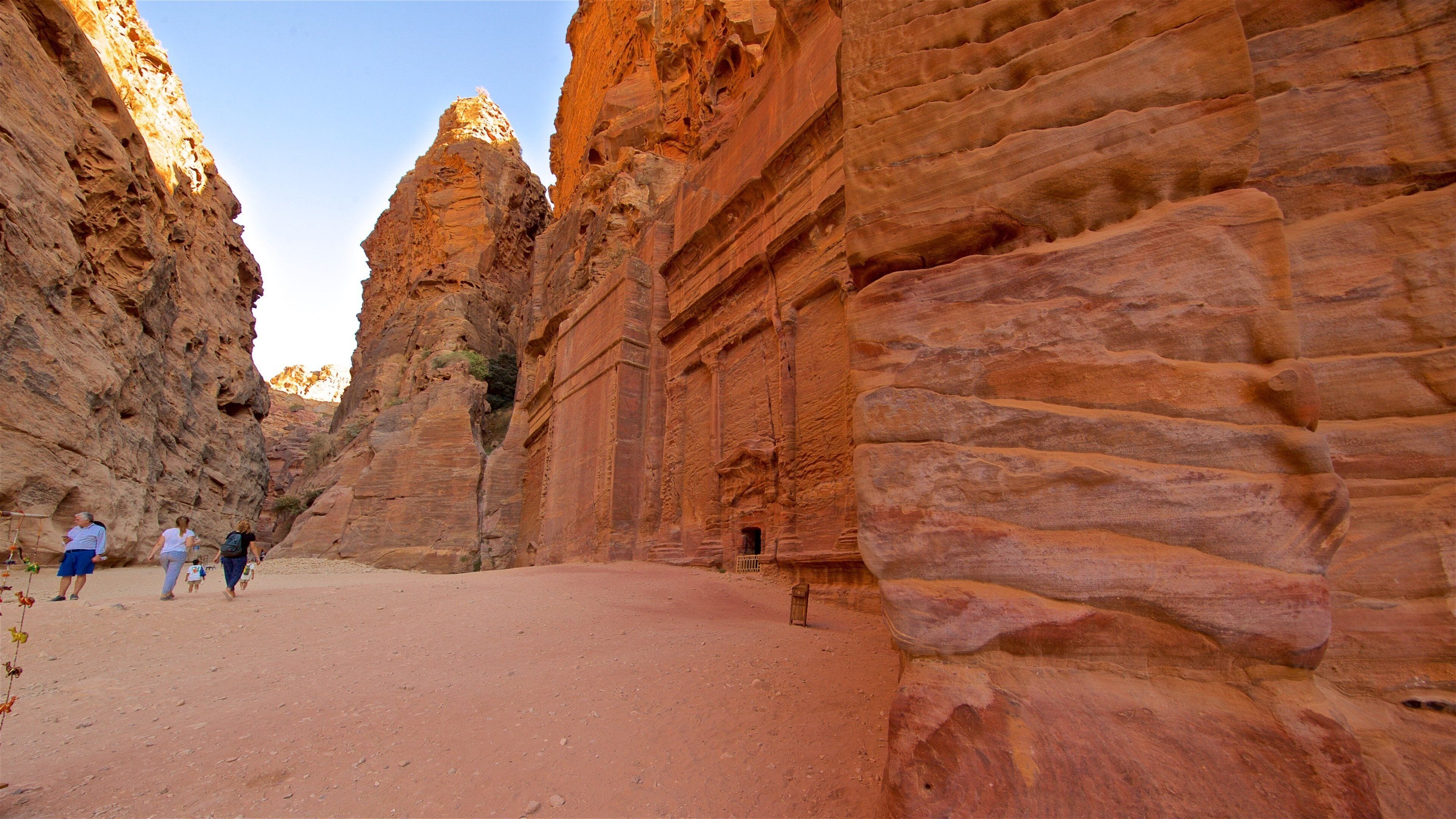 Calle de las fachadas mostrando patrimonio de arquitectura y un barranco o cañón y también un pequeño grupo de personas