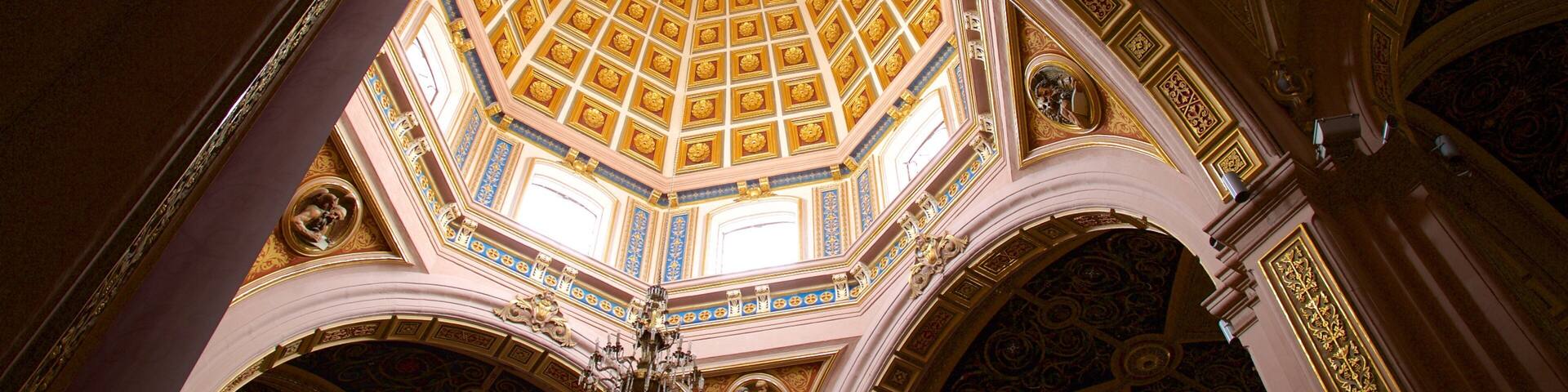 An ornate ceiling with geometric patterns and a central skylight.